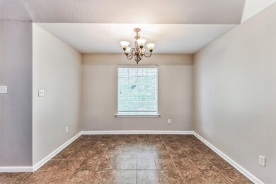 Tiled spare room featuring an inviting chandelier 