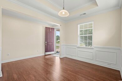 Empty room with crown molding, a raised ceiling, a