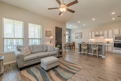 Living area featuring ceiling fan, light wood-typ