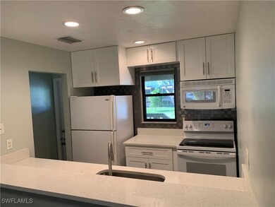 Kitchen featuring white appliances, white cabinets