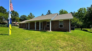 View of front of house with a front lawn, brick siding, a patio area, central AC, and a shingled roof