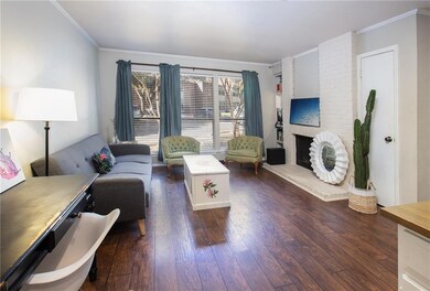 Living area with a fireplace, dark wood-style flo