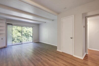 Spare room with wood finished floors and beamed c