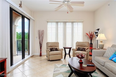 Living room with ceiling fan, light tile patterned flooring, and baseboards