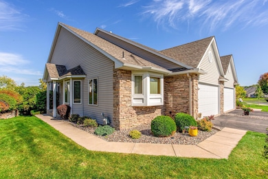 Beautifully maintained townhome with striking stone accents, fresh landscaping, and a welcoming curb appeal.