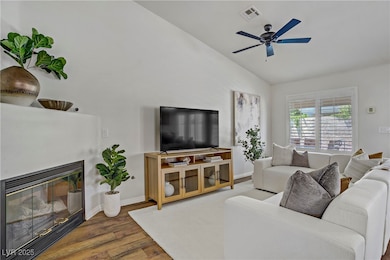 Living room featuring vaulted ceiling, wood finish