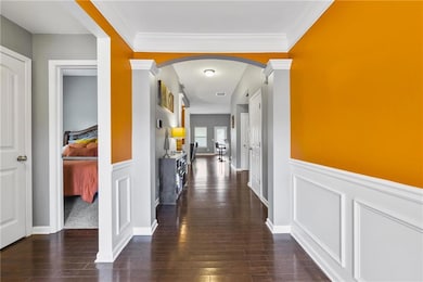 Hall featuring dark wood finished floors, arched w