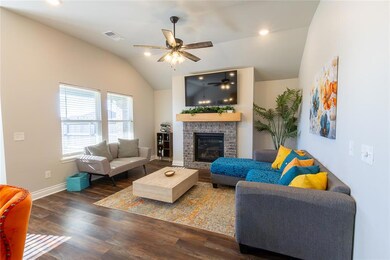 Living room with lofted ceiling, a brick fireplace, dark hardwood / wood-style floors, and ceiling fan