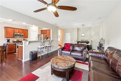 Living room featuring ceiling fan, dark wood finished floors, and baseboards