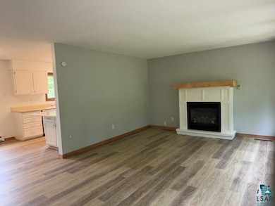 Unfurnished living room with light wood-type flooring and a glass covered fireplace