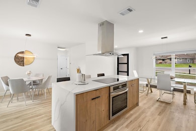 Kitchen with stainless steel oven, island range h