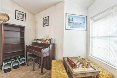 Carpeted home office featuring lofted ceiling and