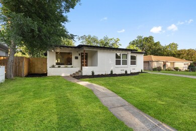 Mid-century inspired home featuring a porch and brick siding
