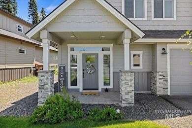 Doorway to property with a garage, covered porch, and roof with shingles