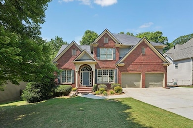 Traditional home with brick siding, concrete driveway, a front lawn, and an attached garage