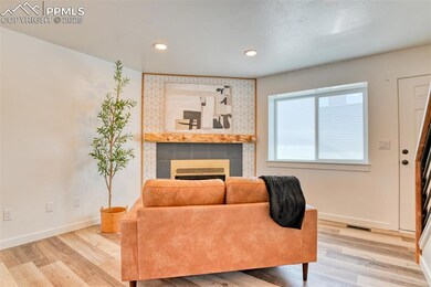 Living area with a fireplace, baseboards, wood finished floors, and recessed lighting