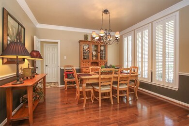 To the right of the front entry is this large formal dining room accented with chair rail and crown molding, warm hardwood floors and plantation shutters.