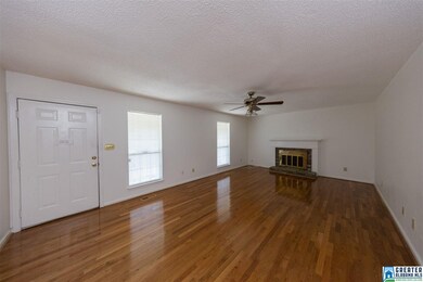 Large living room with hardwood flooring and firep
