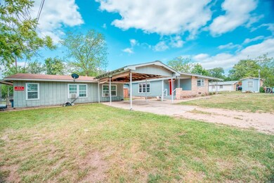 Rear view of property with a lawn, driveway, boar