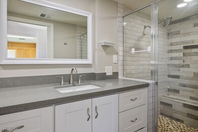 Full bath featuring a stall shower and vanity