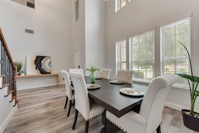 Dining space featuring light hardwood / wood-style floors, a notable chandelier, and a wealth of natural light