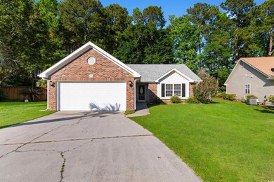 View of front facade featuring brick siding, driveway, and a garage