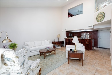Living room featuring a ceiling fan and a high cei