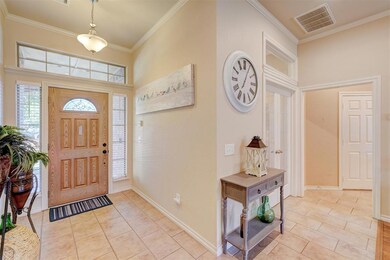 Tiled foyer entrance featuring crown molding