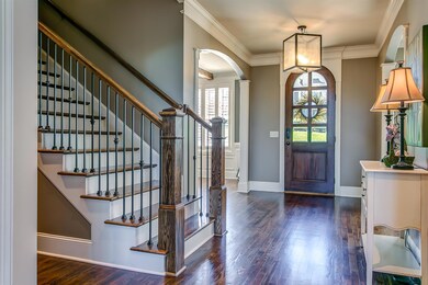 Beautiful arched front door welcomes you into the spacious foyer with gleaming sand and finished hardwood floors