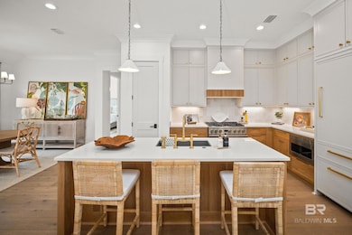 Kitchen with decorative backsplash, recessed lighting, white cabinets, decorative light fixtures, and a breakfast bar