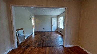 Empty room with dark wood-type flooring and a textured ceiling
