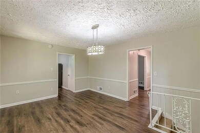 Empty room featuring a textured ceiling and dark wood-type flooring