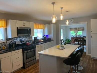 Kitchen featuring backsplash, white cabinets, appl