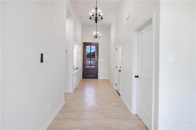 Doorway to outside with a chandelier and baseboards