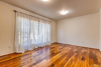 Unfurnished room with ornamental molding and wood finished floors