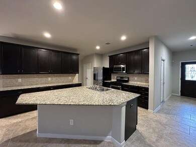 Granite Kitchen Island faceing the Living area. Tile flooring. Soaring ceiling.