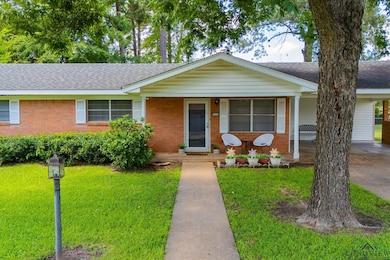 Ranch-style house featuring roof with shingles, a front yard, covered porch, and brick siding
