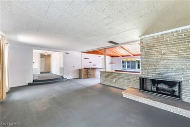 Unfurnished living room featuring a brick fireplac