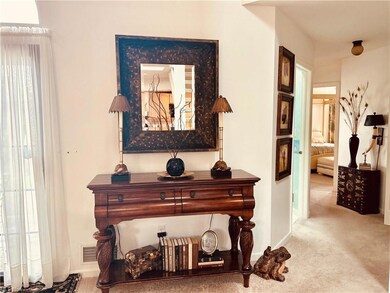 Hall with plenty of natural light and light carpet