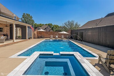 View of pool with an in ground hot tub, pool water