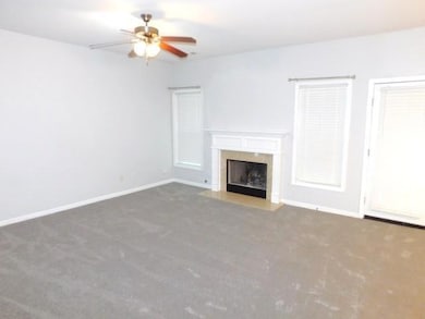 Unfurnished living room featuring carpet flooring, a ceiling fan, and a high end fireplace