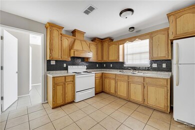 Kitchen featuring white appliances, a sink, backsplash, custom exhaust hood, and light tile patterned floors