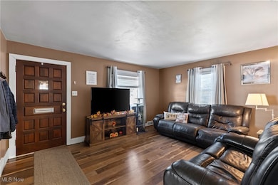 Living area with dark wood-style flooring and baseboards