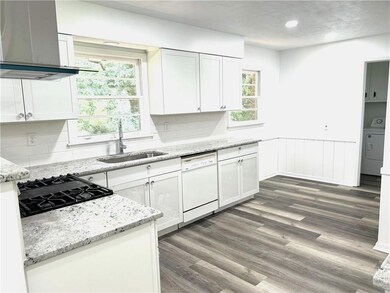 Kitchen featuring wall chimney range hood, tastefu