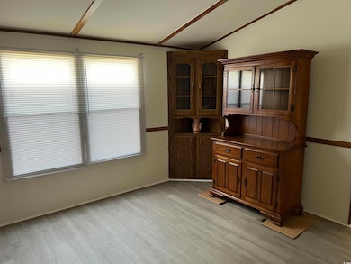 Unfurnished dining area with light wood-style flooring and vaulted ceiling