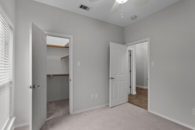 Unfurnished bedroom with ceiling fan, a walk in cl
