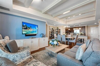Dining area with dark hardwood / wood-style flooring, ornamental molding, and a notable chandelier