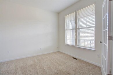 Carpeted office with french doors.