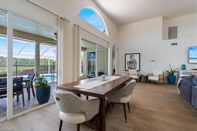 Dining room with a high ceilings with sliders that flow to outside screened lanai and pool