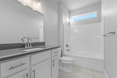 Full bathroom featuring shower / bathtub combination, vanity, and light marble finish floors